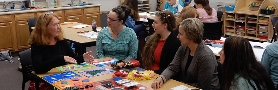 students and professor sitting in early childhood classroom